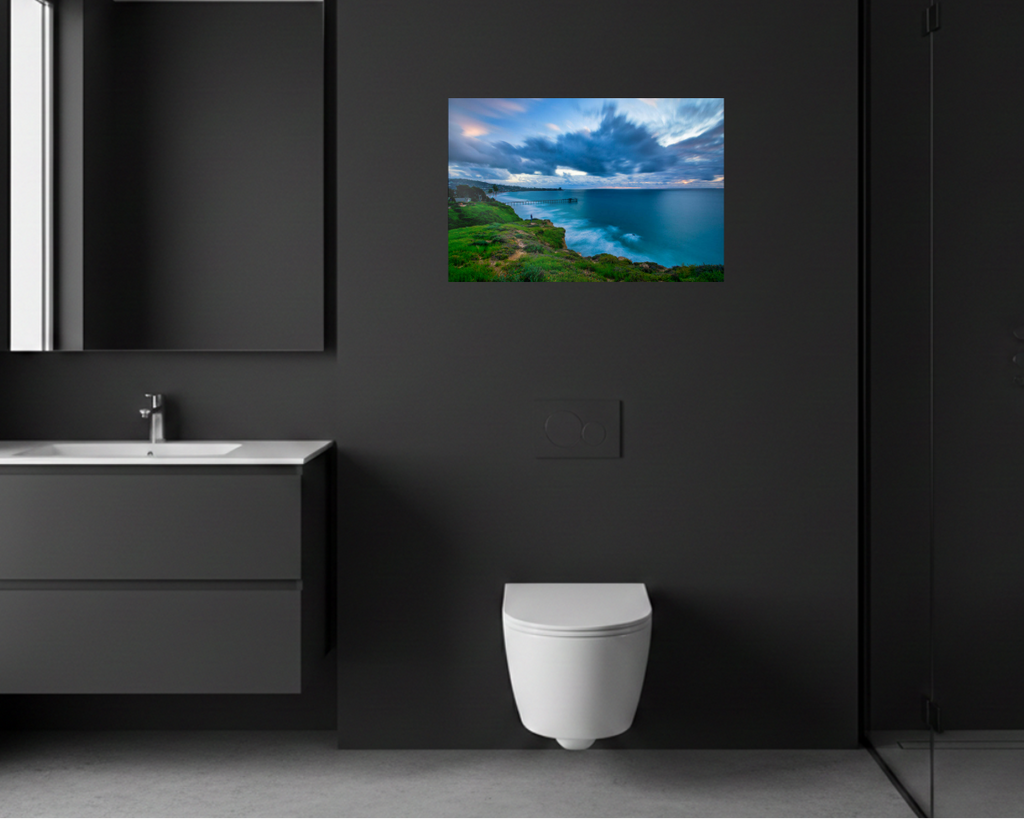 Bathroom with a black wall, white toilet, and a mounted TV displaying a scenic view.