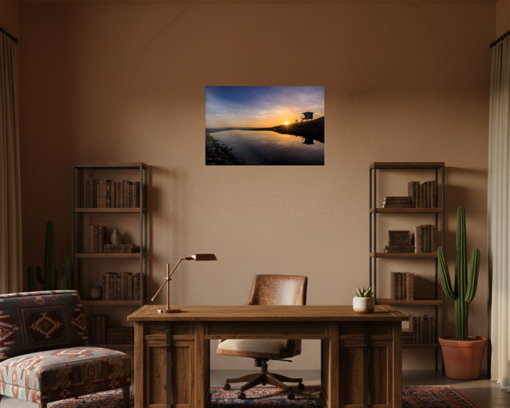 Home office with a desk, chair, and wall art of a sunset over water.